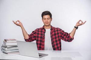 A man uses a laptop in the office and makes a hand sign OK. photo