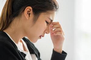 The sick woman had a headache and put her hand on her nose on the bed. photo