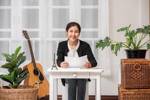 A woman sitting happily at the desk analyzes documents. photo