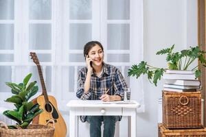 Women sit at the desk and use the phone to coordinate. photo