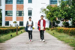 los estudiantes masculinos y femeninos usan un rostro frío y se paran frente a la universidad. foto