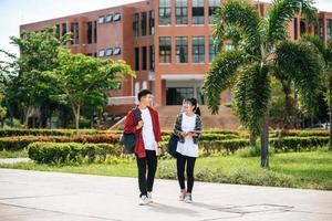 Male and female students wear a face Chill and stand in front of the university. photo