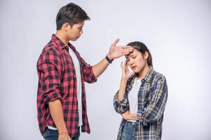 A sick woman had a man look and touch his forehead. photo