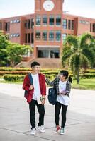 los estudiantes masculinos y femeninos usan un rostro frío y se paran frente a la universidad. foto