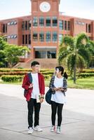 los estudiantes masculinos y femeninos usan un rostro frío y se paran frente a la universidad. foto