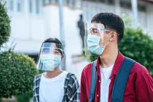 Male and female students wear face chill and masks Walk the footpath photo