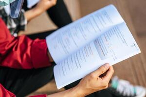 un estudiante con una máscara y sentado leyendo. foto