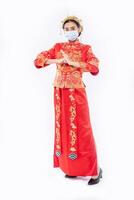 Woman wear Cheongsam suit and black shoe with mask welcome everyone to come in shop photo