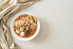 noodles with pork and meatballs in spicy soup photo