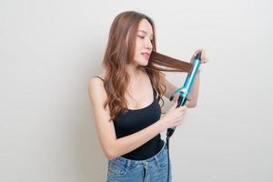 Retrato hermosa mujer asiática con rizador de pelo o rizador foto