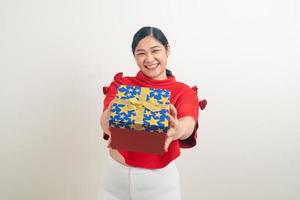 happy Asian woman wearing red shirt with gift box on hand for Christmas festival photo