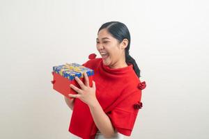 happy Asian woman wearing red shirt with gift box on hand for Christmas festival photo