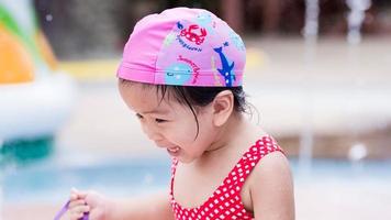 Happy Asian baby cute girl in water park. Portrait child laugh and smile brightly. Summer time. Kid aged 3 years old. photo