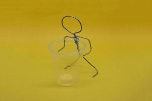 Human figure made of metal wire with an object photo