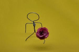 Figura humana hecha de alambre de metal con un objeto. foto