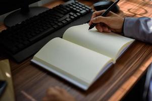 businessman reading and writing book at work photo