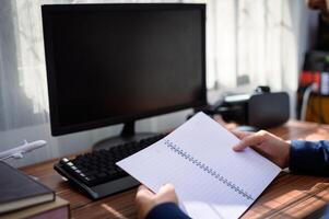 businessman reading and writing book at work photo