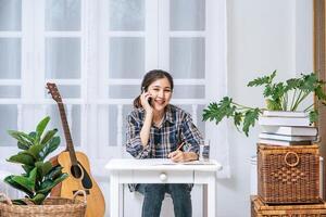 Women sit at the desk and use the phone to coordinate. photo