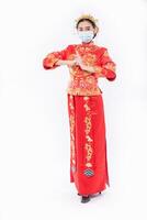 mujer usa traje cheongsam y máscara respeta a su padre y a su madre en el año nuevo chino foto