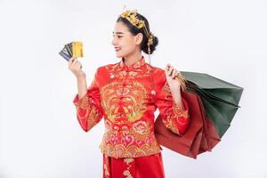 mujer usa traje cheongsam obtener muchas cosas al usar tarjeta de crédito en el año nuevo chino foto
