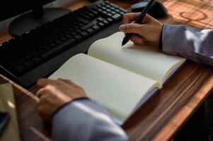 businessman reading and writing book at work photo