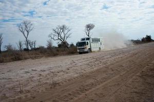 Desierto de Kalahari, Namibia, 2016, un camión para turistas corriendo por una carretera de arena en Namibia. polvo detrás de la pista, no más vehículos. Namibia.