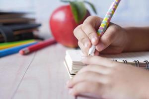 child hand writing on notepad photo