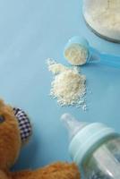 Close up of baby milk powder and spoon on tile background. photo