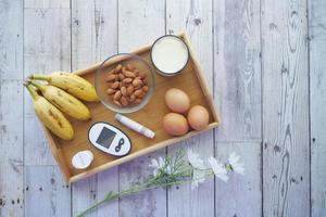 herramientas de medición para diabéticos, plátano, huevos, leche en la mesa foto