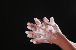 young man washing hands with soap warm water photo