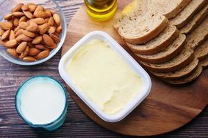 mantequilla, leche, pan y nueces de almendras en la mesa foto