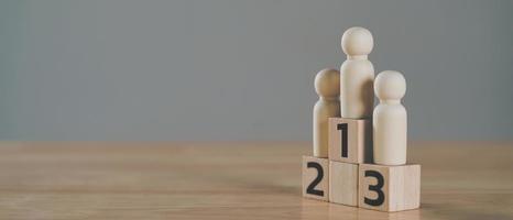 wooden figures peg doll standing on the podium 1st, 2nd, 3rd positions of wooden cube blocks with copy space. ranking and strategy concept. photo