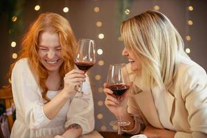 lesbian couple having dinner in a restaurant. Girls drink wine and talk photo