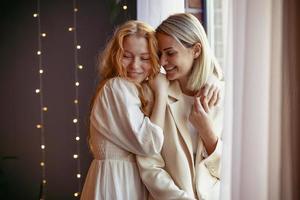 lesbian couple having dinner in a restaurant. One girl hugs her beloved whispering in her ear photo