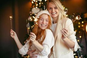 lesbian couple having dinner celebrating a holiday. Girls burn sparklers and smile at the camera photo