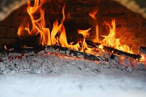 fireplace with log wood burning clay stove fire in home in the winter - fireplace room concept photo