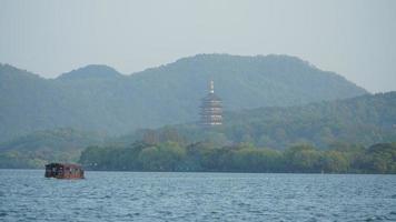 The beautiful lake landscapes in the Hangzhou city of the China in spring with one old temple tower located on the shore photo