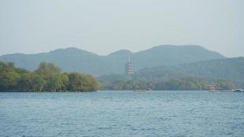 The beautiful lake landscapes in the Hangzhou city of the China in spring with one old temple tower located on the shore photo