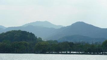 The beautiful lake landscapes in the Hangzhou city of the China in spring with the peaceful lake and fresh green mountains photo