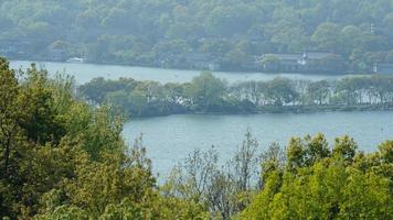 The beautiful lake landscapes in the Hangzhou city of the China in spring with the peaceful lake and fresh green mountains photo