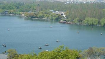 The beautiful lake landscapes in the Hangzhou city of the China in spring with the peaceful lake and fresh green mountains photo