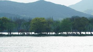 The beautiful lake landscapes in the Hangzhou city of the China in spring with the peaceful lake and fresh green mountains photo