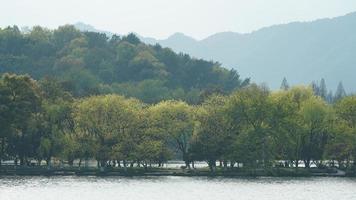 The beautiful lake landscapes in the Hangzhou city of the China in spring with the peaceful lake and fresh green mountains photo