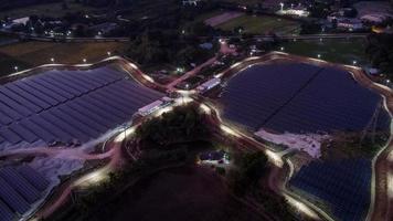 Vista aérea de una granja solar que produce energía limpia durante la noche con crepúsculo y visible en todo el área. foto
