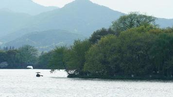 The beautiful lake landscapes in the Hangzhou city of the China in spring with the peaceful lake and fresh green mountains photo