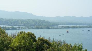 los hermosos paisajes lacustres en la ciudad china de Hangzhou en primavera con el lago tranquilo y las montañas verdes frescas foto