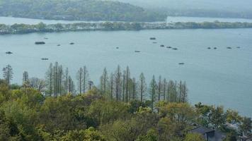 The beautiful lake landscapes in the Hangzhou city of the China in spring with the peaceful lake and fresh green mountains photo