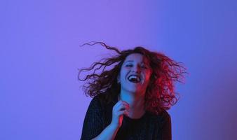 Girl dancing and having fun at party. Colorful light, Studio shot, copyspace photo