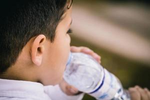 Little boy drinking water. Close up and copy space photo