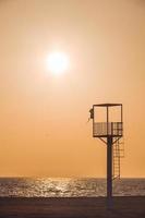 Almerimar beach lifeguard tower at sunset. Deserted beach, no people. Almeria, Andalusia, Spain photo